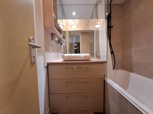 une salle de bain avec un lavabo, une baignoire et un miroir dans l'établissement Appartement avec jardin, à Paris