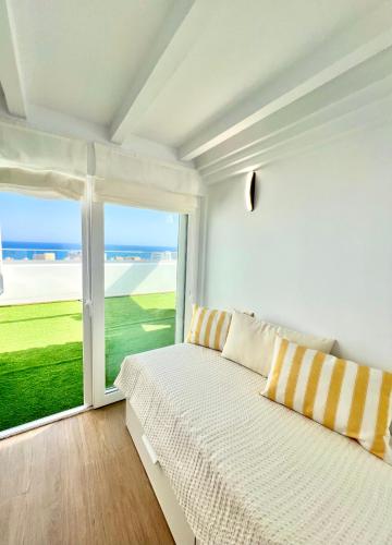 a white bedroom with a bed and a large window at Summer Dream House in Torremolinos