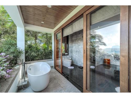 une salle de bain avec baignoire et toilettes et une fenêtre dans l'établissement Luxury 7 Bedroom Villa In Layan, à Layan Beach