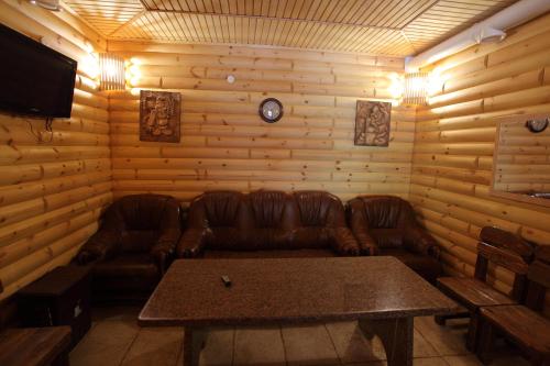 a living room with a leather couch and a table at Pidkova in Rivne