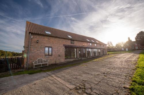 a brick building on a street with the sun in the sky at The Granary in Martin