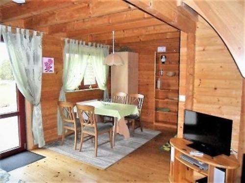 a dining room with a table and chairs and a television at Ferienhaus Bliev-Hee Nr 3 in Klink