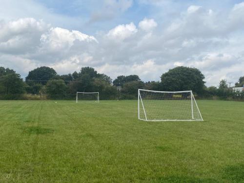 a soccer field with a goal in the grass at POPPY LUXURY LODGE Sleeps 8 at Fairview Farm, Ravenshead, Nottingham Near Sherwood Forest, Dog Friendly, Farm Stay great for wedding groups, families, Hen Do's, friends gatherings with amazing views in Blidworth
