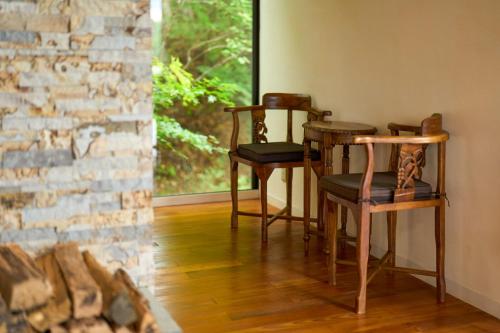 two chairs and a table in a room with a brick wall at Suite Villa Oshino Mt FUJI in Oshino