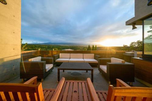 a patio with a table and chairs and the sunset at Suite Villa Oshino Mt FUJI in Oshino