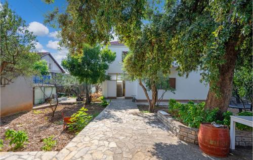 a white house with trees and a walkway at Lovely Apartment In Brodarica With Wifi in Brodarica