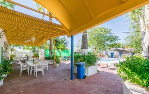 a patio with a table and chairs under a yellow umbrella at 6 Bedroom Amazing Home In Lucena in Lucena