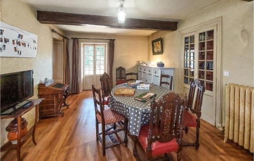 a dining room with a table with chairs and a television at 7 Bedroom Awesome Home In Charlieu in Charlieu