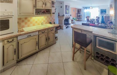 une cuisine avec des placards blancs et un grand îlot de cuisine dans l'établissement 2 Bedroom Stunning Home In Abeilhan, à Abeilhan