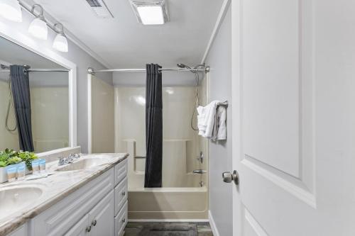 a white bathroom with a sink and a shower at Spectacular Oceanview Condos in Myrtle Beach
