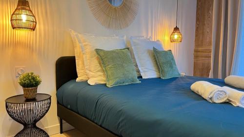 a bedroom with a bed with blue sheets and pillows at Les terrasses de Villevaudé - Disneyland Paris in Villevaudé