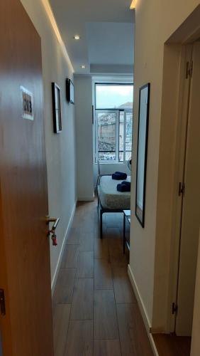 a hallway with a room with a bed and a window at Figueira House in Beira Minho in Lisbon