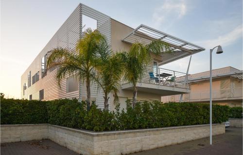 ein Gebäude mit einer Palme davor in der Unterkunft Cozy Home In Marina Di Ragusa With Wifi in Marina di Ragusa