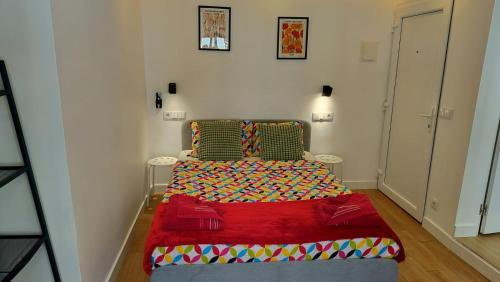 a small bedroom with a bed with a red blanket at Figueira House in Beira Minho in Lisbon