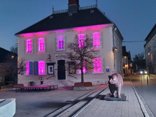 a building with pink lights on it with a statue in front at Lumineux studio vue montagne cote 2000 in Villard-de-Lans