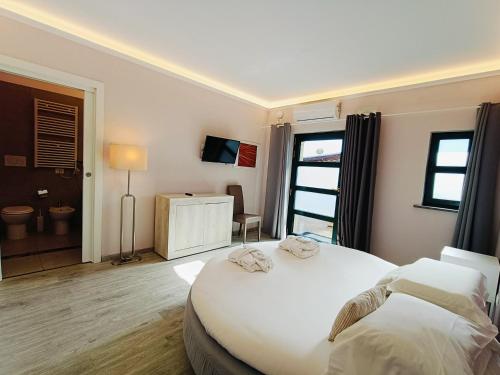 a bedroom with a large white bed and a bathroom at Domus Volumnia Country House in Perugia