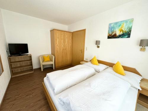 a bedroom with a bed with white sheets and yellow pillows at Am Dörfl in Tux