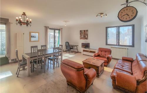 - un salon avec une table, des chaises et une horloge dans l'établissement Cozy Apartment In Béziers With Wi-Fi, à Béziers