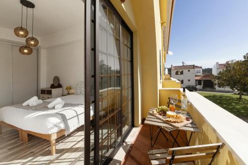 a bedroom with a bed and a table on a balcony at Casa do Convento in Óbidos