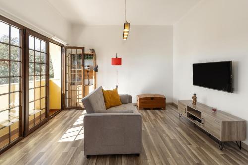 a living room with a couch and a flat screen tv at Casa do Convento in Óbidos