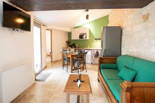 un salon avec un canapé vert et une table dans l'établissement La Palmeraie de Distré - Avec jardin, à Distré