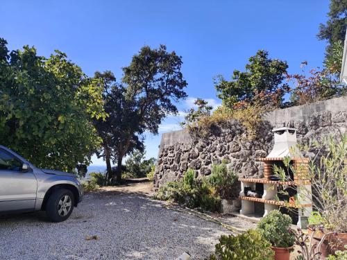 a car parked next to a stone wall with a light at Quinta da Barroquinha in Vale de Prazeres
