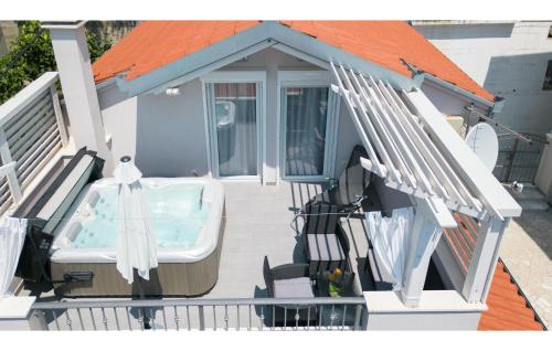 a deck with a bath tub on a house at Three-Bedroom Holiday Home In Suhi Potok in Jesenice