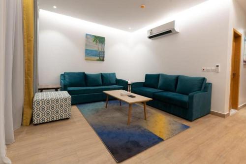 a living room with a blue couch and a table at شاليه نور بشاطئ البرادايس بدرة العروس - للعائلات فقط in Durat  Alarous