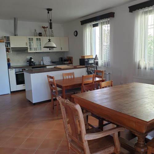 a kitchen and dining room with a wooden table and chairs at Pottos Porta in Váncsod