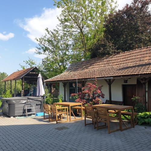 a patio with tables and chairs and a grill at Pottos Porta in Váncsod