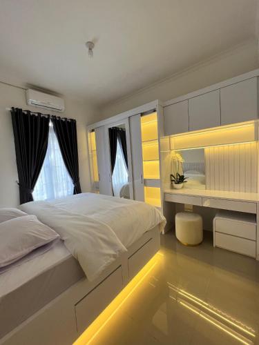a bedroom with a large white bed and a mirror at The Villas in Bogor