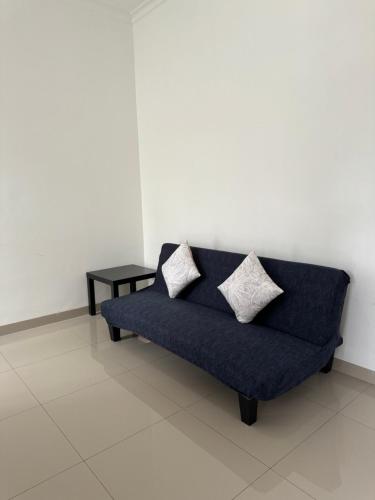 a blue couch with two pillows sitting in a room at The Villas in Bogor