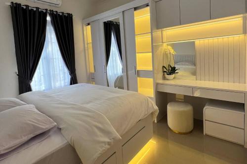 a bedroom with a bed and a vanity and a mirror at The Villas in Bogor
