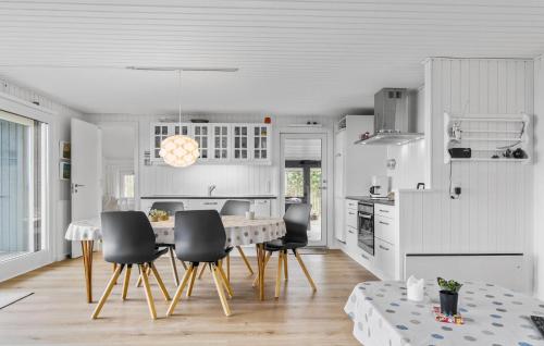 a white kitchen with a dining table and chairs at 3 Bedroom Lovely Home In Bjert in Binderup Strand