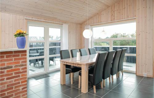 a dining room with a wooden table and black chairs at Holiday Home Astavej Løkken in Løkken