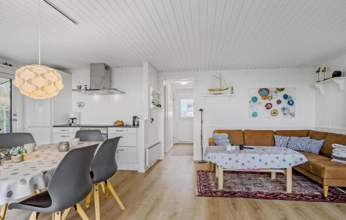 a living room with a table and a couch at 3 Bedroom Lovely Home In Bjert in Binderup Strand