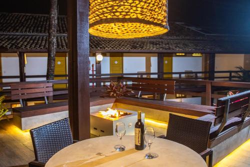 a restaurant with two tables and two wine glasses at Hotel Vilarejo Praia in Rio das Ostras