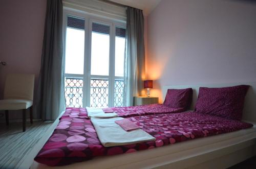 een slaapkamer met een paars bed en een raam bij Pulse Jackquaters in Boedapest