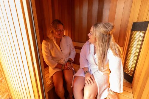 two women sitting next to each other on a boat at Zonneweelde, Vakantie aan Zee in Nieuwvliet-Bad