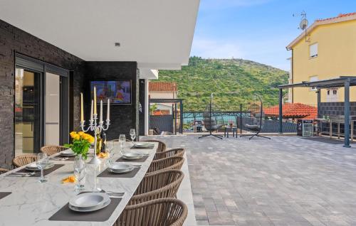 un lungo tavolo con piatti e fiori su un patio di 6 Bedroom Stunning Home In Podglavica a Podglavica