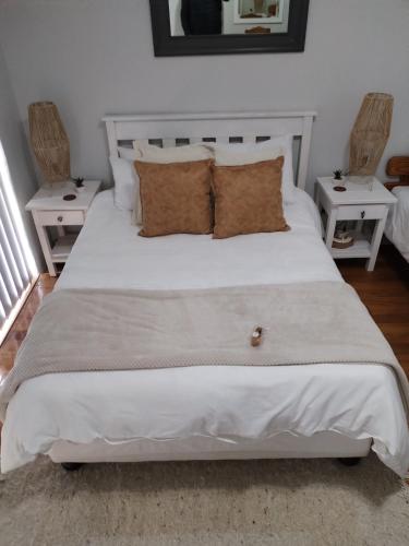 a bedroom with a white bed with two white tables at 420 on Cape in Port Elizabeth
