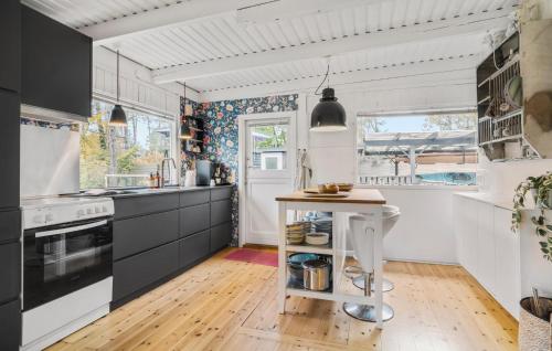 a kitchen with black and white cabinets and a table at Awesome Home In Asnæs With Wifi in Asnæs