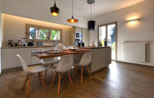 eine Küche mit einem Holztisch und weißen Stühlen in der Unterkunft Amazing Home In Balestrate With Wifi in Balestrate