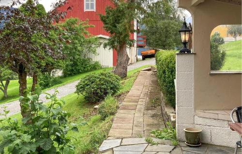a walkway leading to a house with a red building at 5 Bedroom Gorgeous Home In Hundeidvik in Hundeidvik