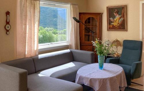 a living room with a couch and a table and a window at 5 Bedroom Gorgeous Home In Hundeidvik in Hundeidvik