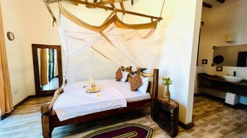 a bedroom with a bed with a mosquito net at Z-Breeze Zanzibar in Kiwengwa