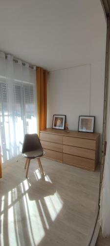 une chaise assise dans une pièce avec miroir dans l'établissement APPARTEMENT 4 à 6 Pers, au Cap d'Agde