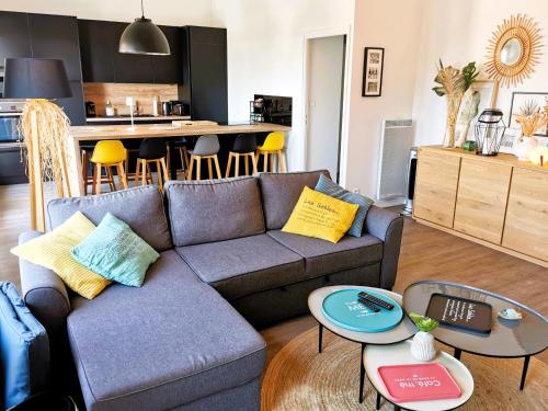 Il comprend un salon avec un canapé et des tables ainsi qu'une cuisine. dans l'établissement Au Paradis Sablais, à Les Sables-dʼOlonne