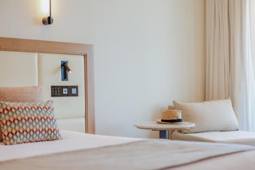 a bedroom with a bed and a hat on a table at Golden Coast Beach Hotel in Protaras