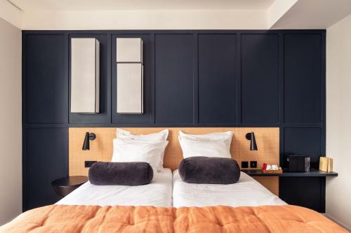 a bedroom with a large bed with two pillows on it at Hôtel Maison Traversière in Paris